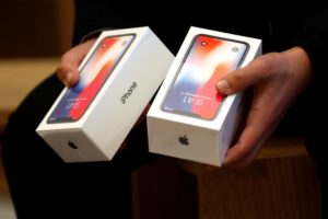 FILE PHOTO A man holds two boxes for the Apples new iPhone X at the Apple Store in Regents Street